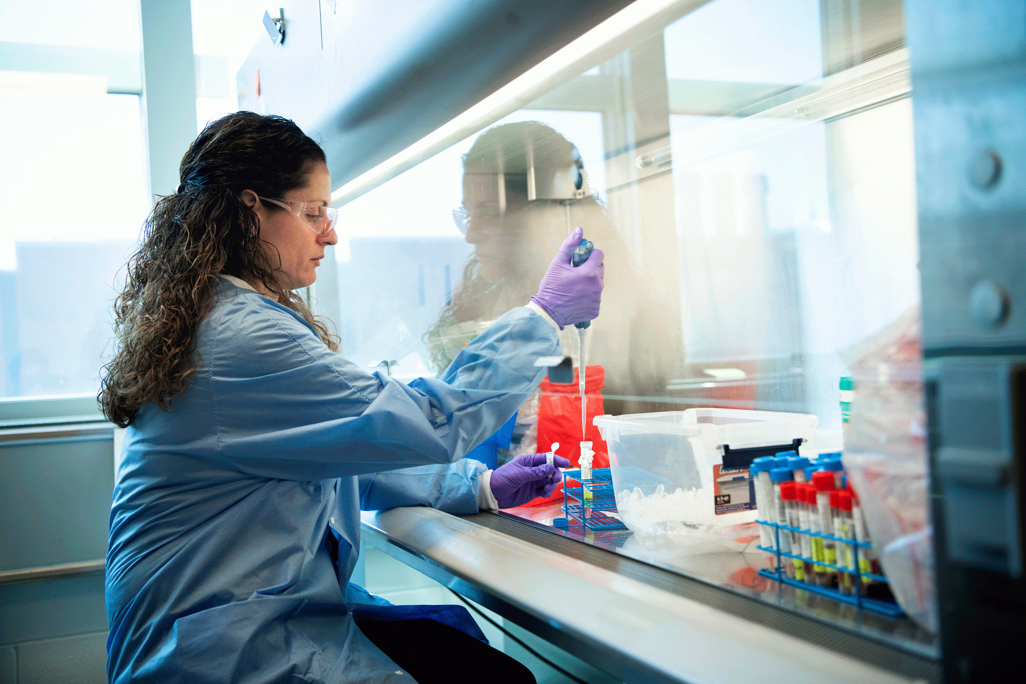 Image of woman in lab wearing protective equipment