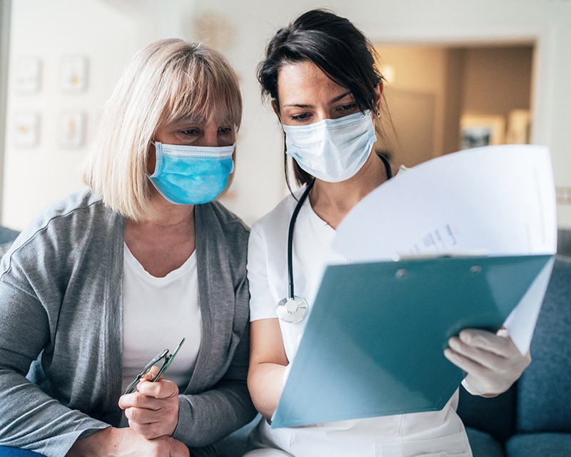 Nurses wearing face masks and reading paper files