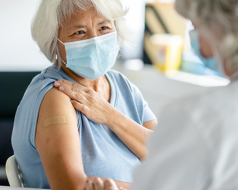 Woman wearing a bandage on her arm after a flu shot