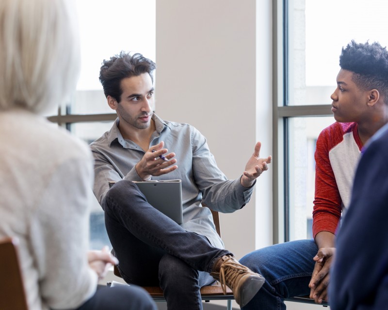 Three people speaking in a collaborative circle.